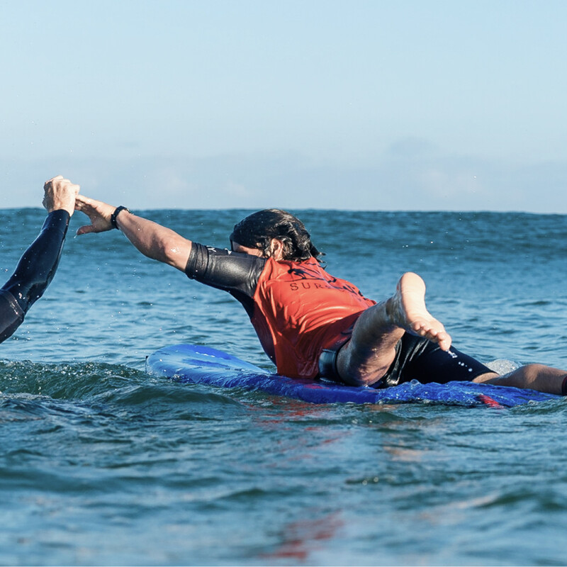 Zwei Surfer im Wasser, die sich abklatschen