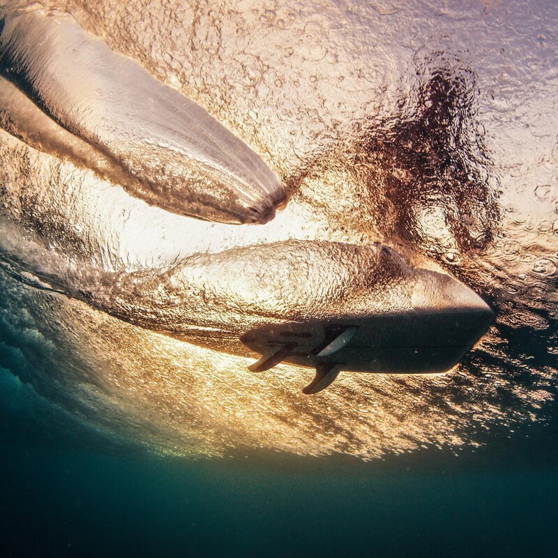 Surfer in einer Welle aus der Perspektive unter Wasser