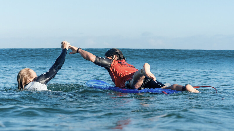 Zwei Surfer im Wasser, die sich abklatschen