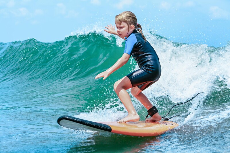 Young girl surfing a wave